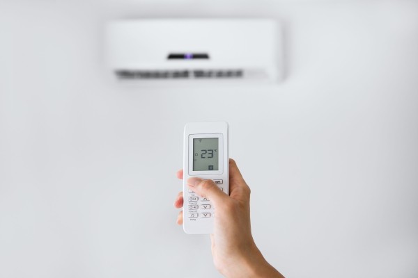 Image of someone setting their air conditioner to the optimum temperature.