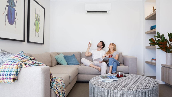 daikin-aircon-dry-mode 2 people sitting on the couch under a daikin aricon turning it to dry mode