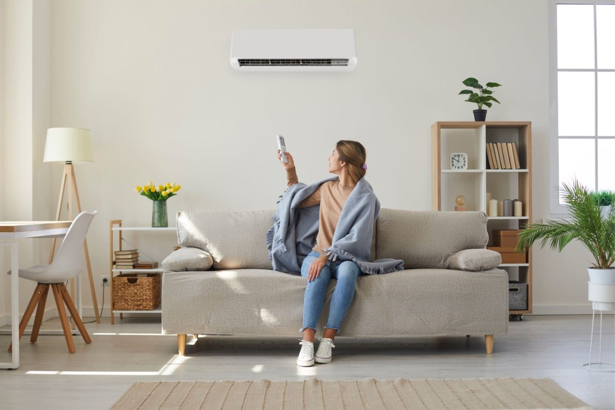 A person setting their air conditioner in winter. 